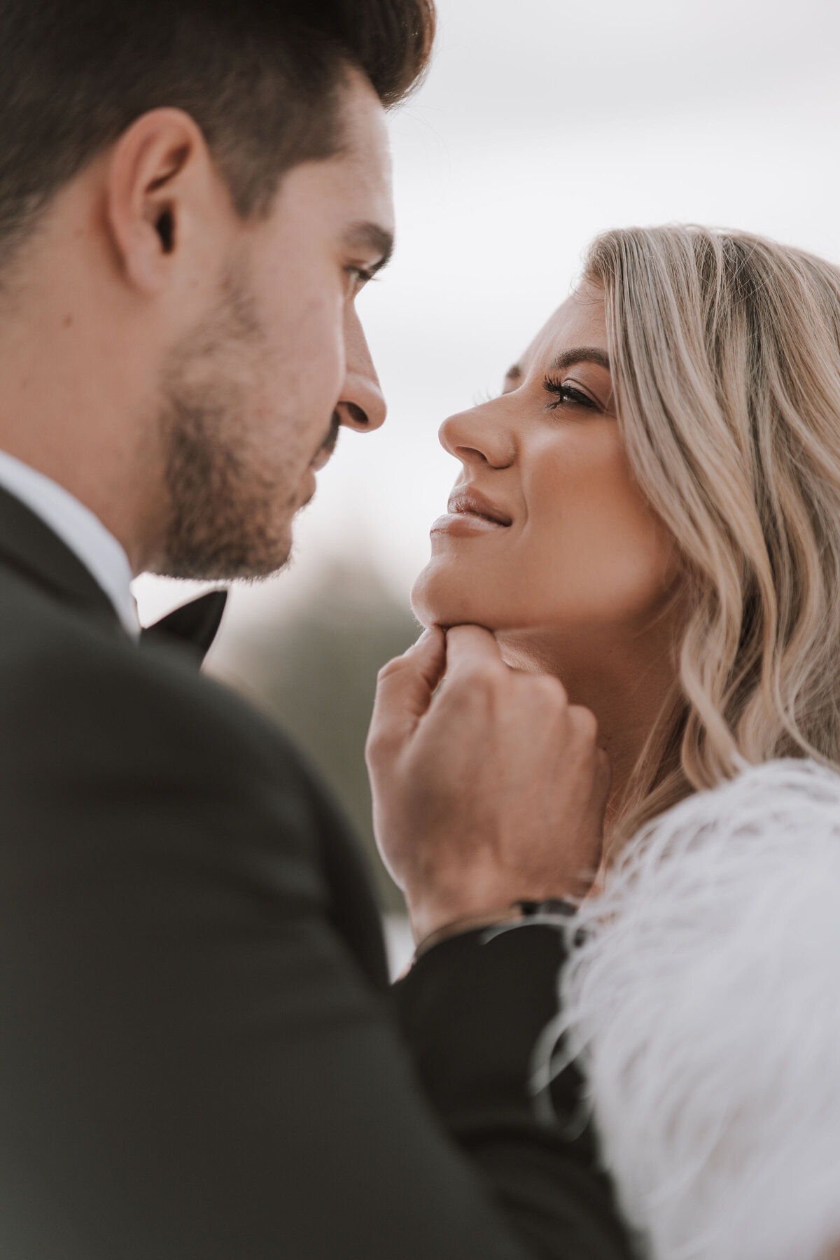 Bride and groom kiss while groom lifts brides face with the tip of his knuckle captured by Idaho Falls Wedding Photographer