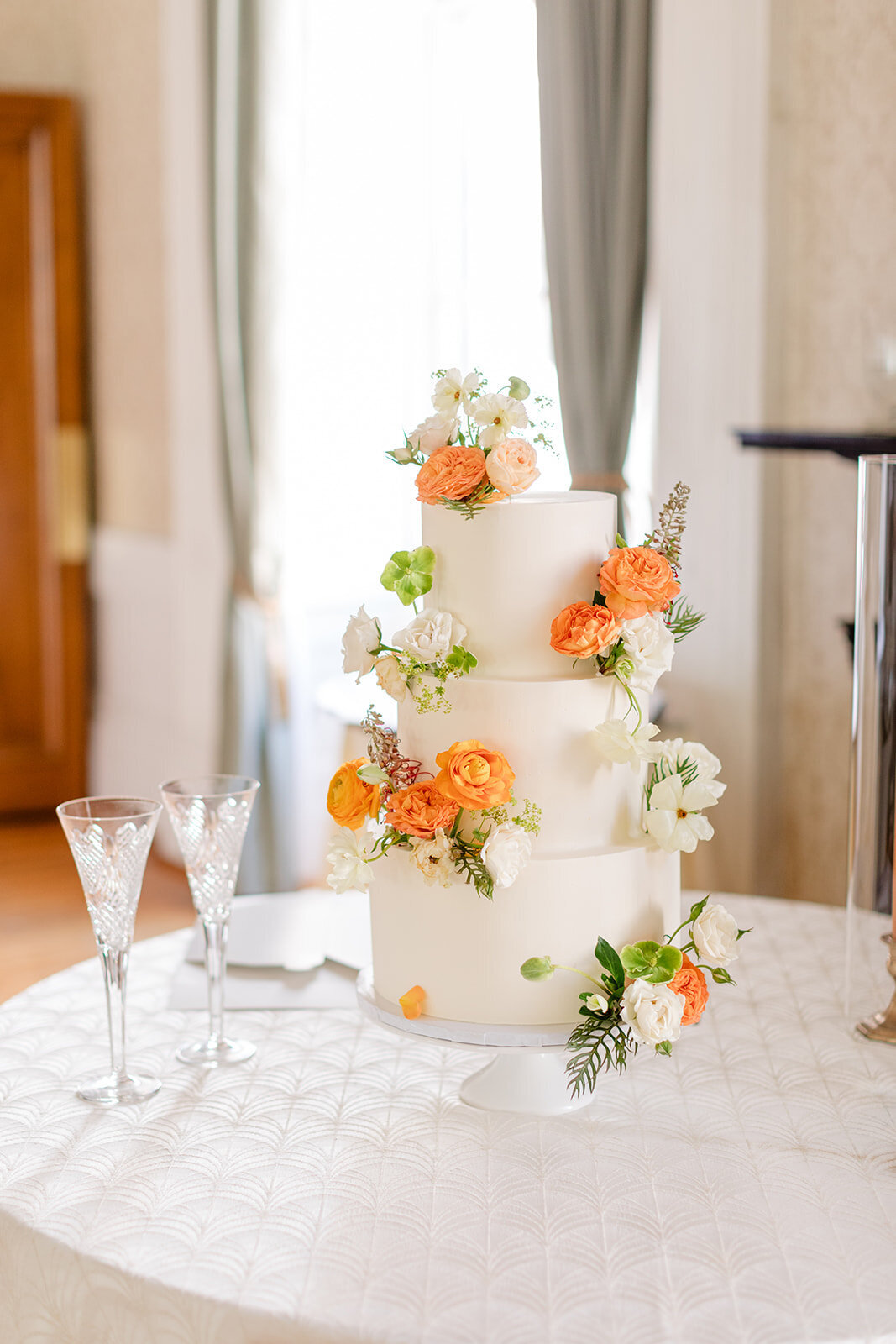 Wedding cake with orange flowers at Hibernian Hall; Charleston, South Carolina