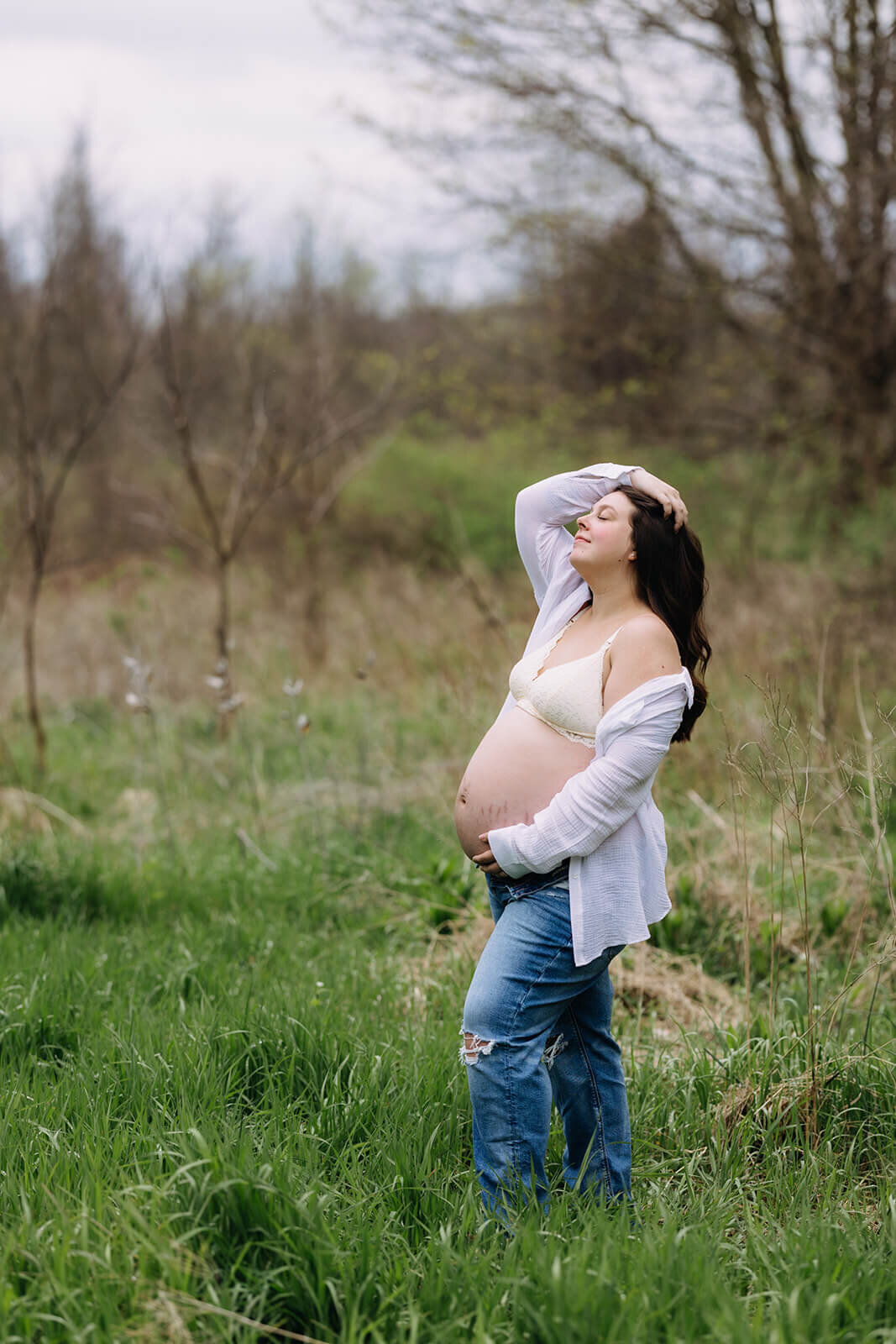 Woman with bare baby bump in field at  Finger Lakes Maternity session