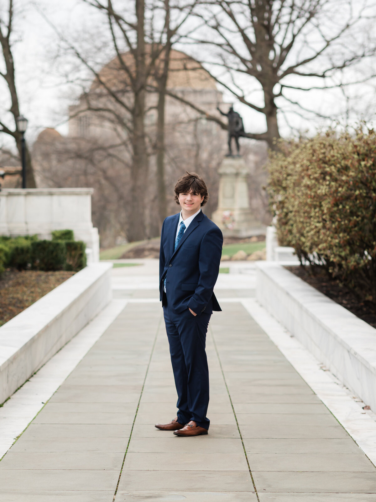 high school senior boy in blue suit posed at Cleveland Museum of Art for portraits 