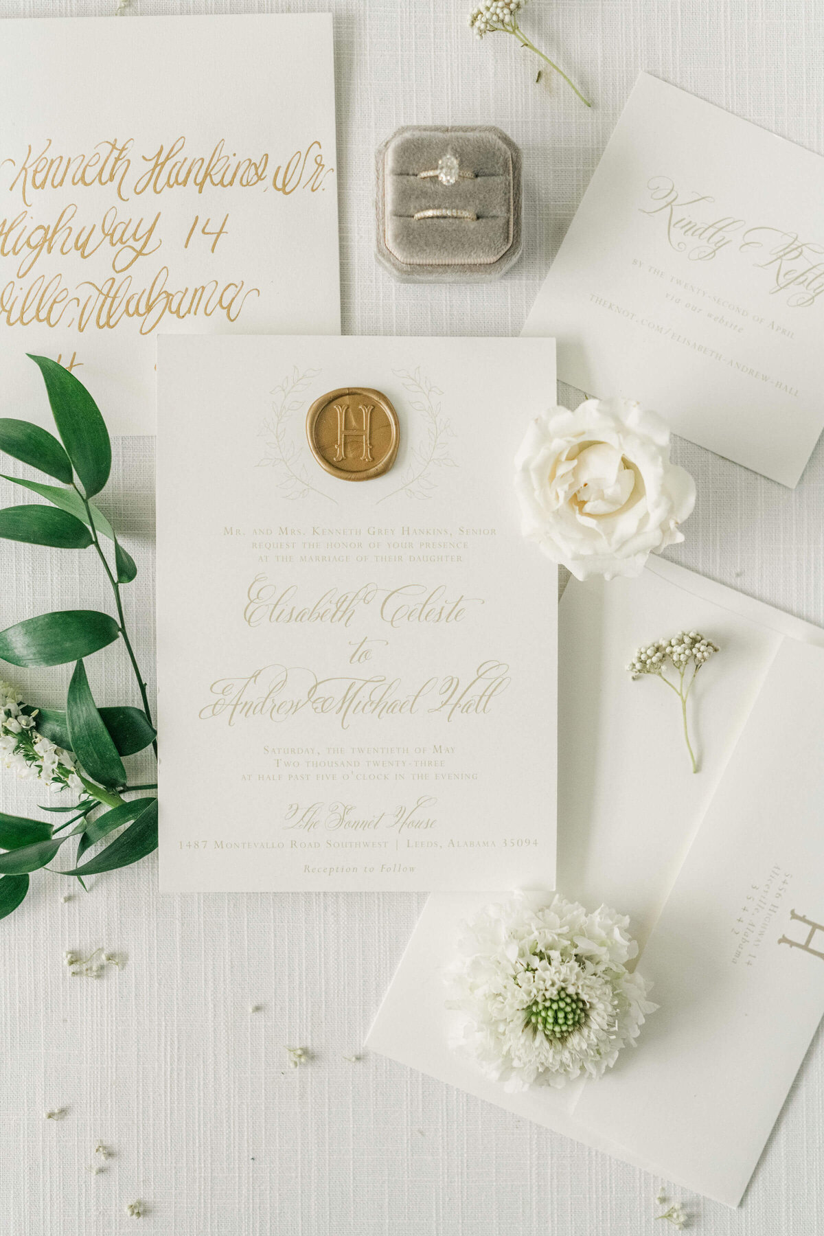 Wedding stationary styled for flat lay wit˙ greenery and gold accents