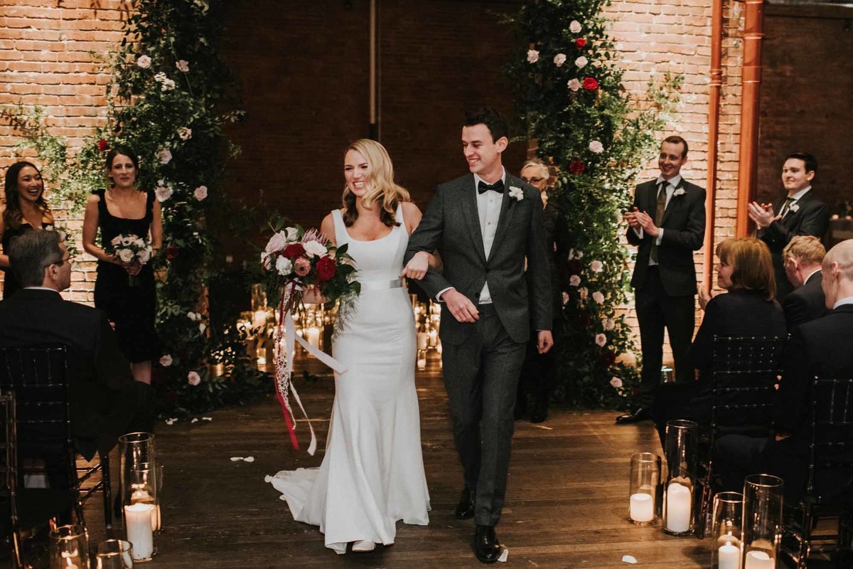 bride and groom just married at Axis Pioneer Square Seattle with grand greenery arbor