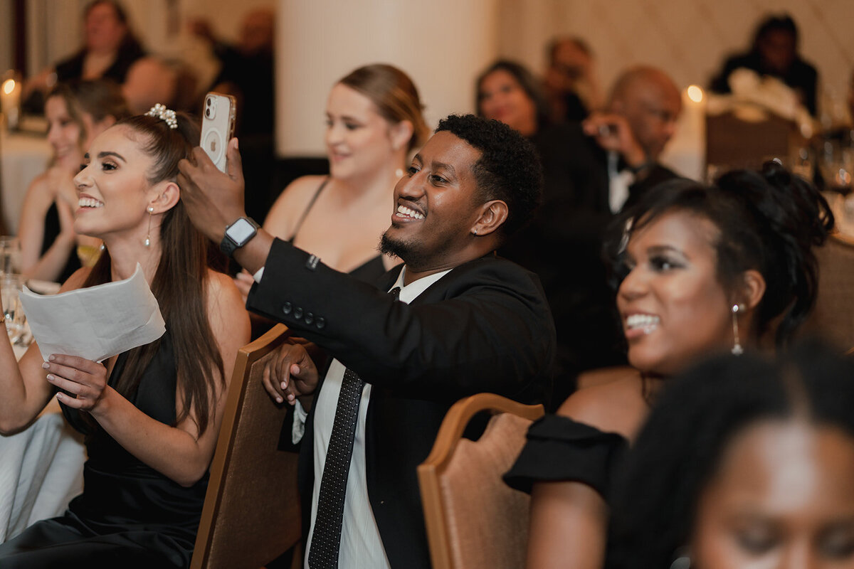 black wedding guests smiling taking photos with phone