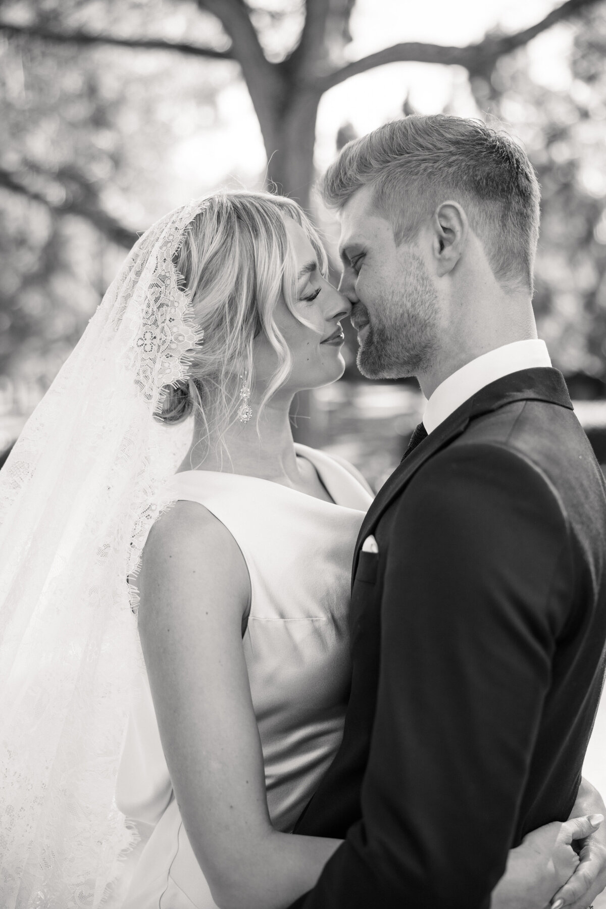 Black and white close-up of bride and groom touching noses in Dayton, Ohio, by Philadelphia wedding photographer.