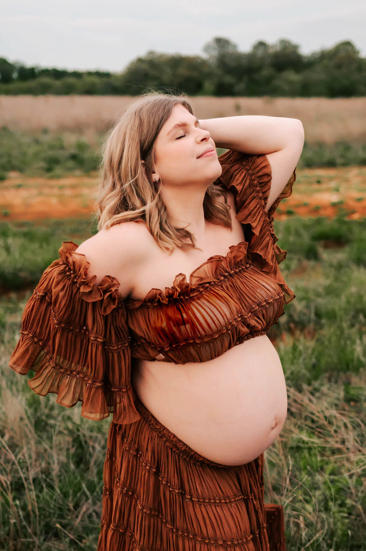 maternity photo in Branson MO of pregnant mom closing her eyes in a field