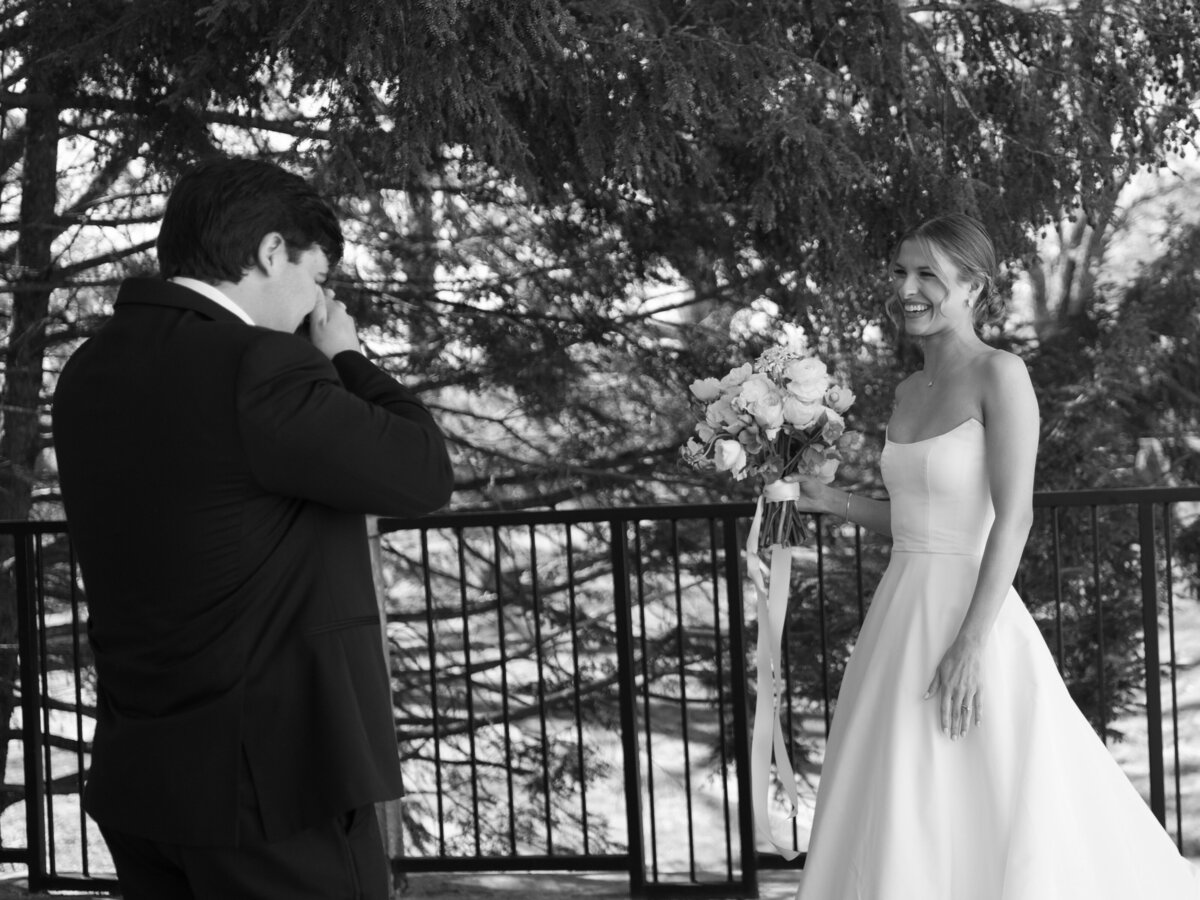 Black and white photo of the groom becoming emotional as he sees the bride for the first time during their wedding day at Burritt on the Mountain in Huntsville, Alabama, photographed by Perry Hancock.
