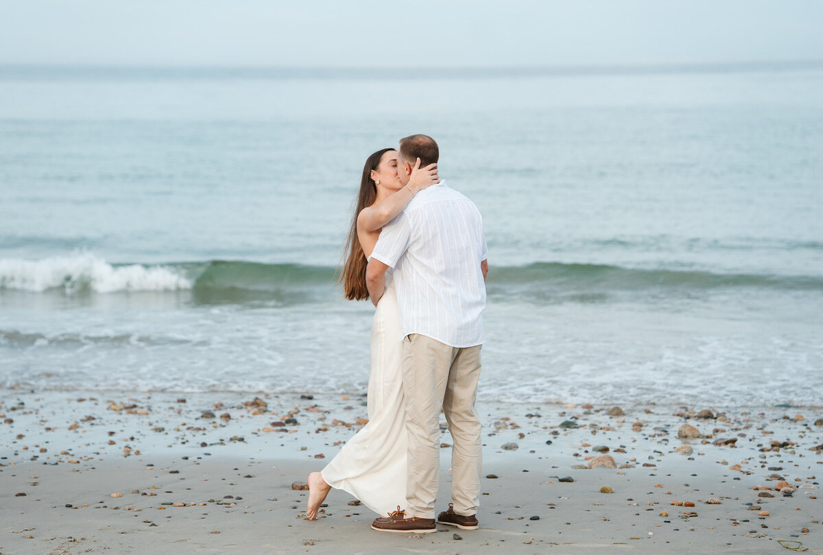 New England beach engagement photos during a sunset coastal session with candid moments.