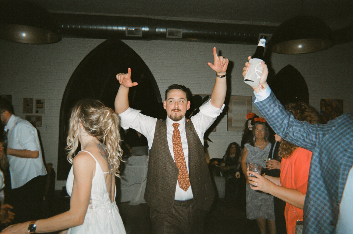 documentary photograph of a groom dancing at his wedding reception captured on 35mm film by Texas and Los Angeles wedding photographer