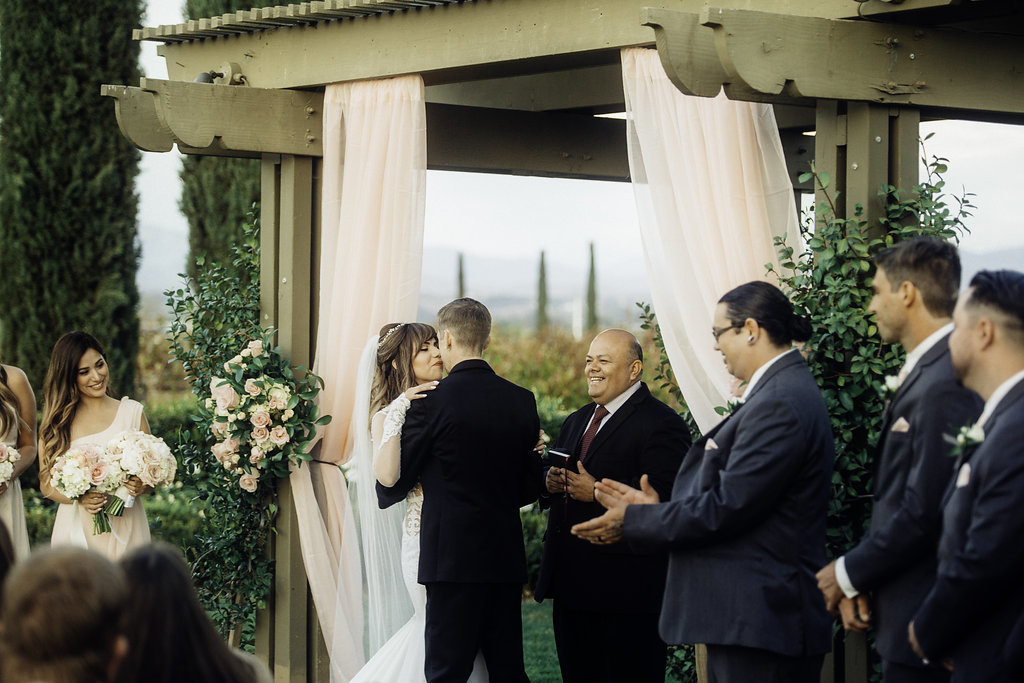 Wedding Photograph Of Bride And Groom Kissing During Wedding Ceremony Los Angeles