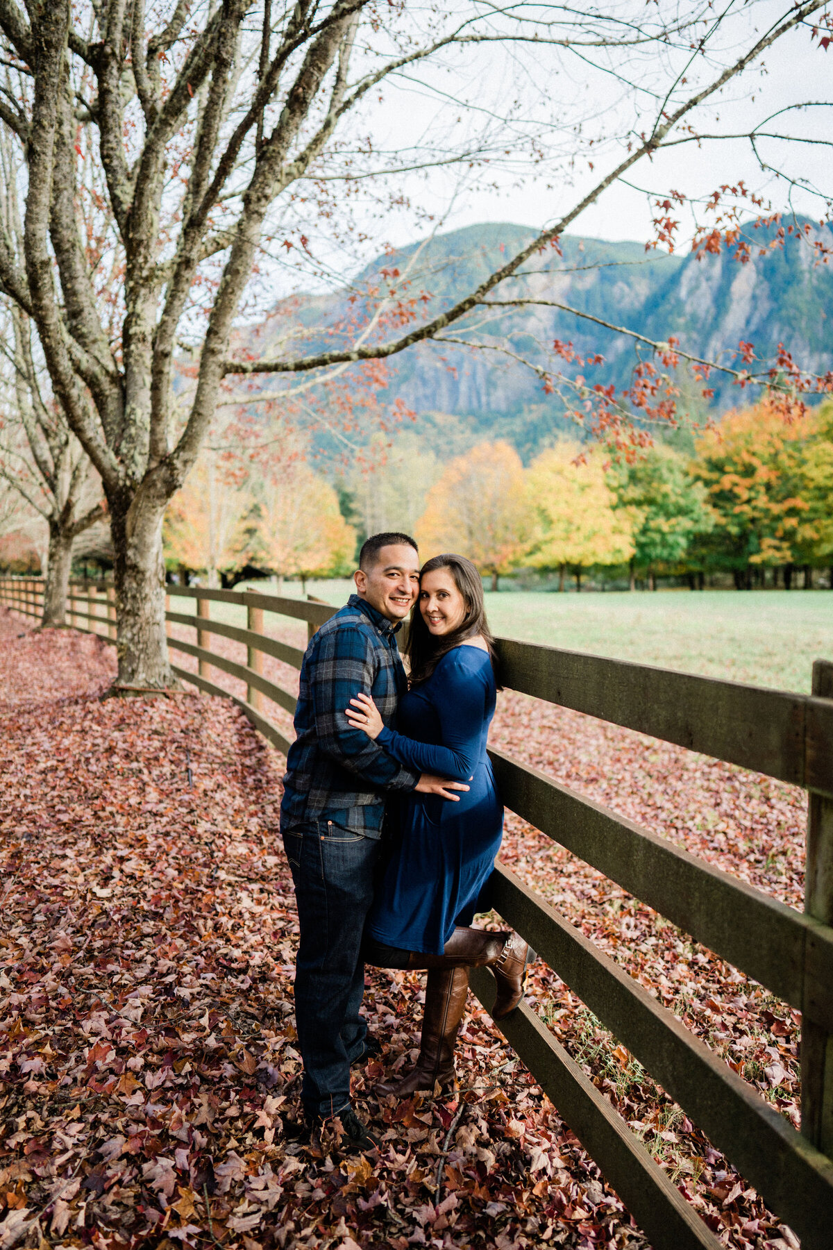 Couple hugs and kisses at Rockwood Farm, best spot for engagement photos with fall color in Seattle