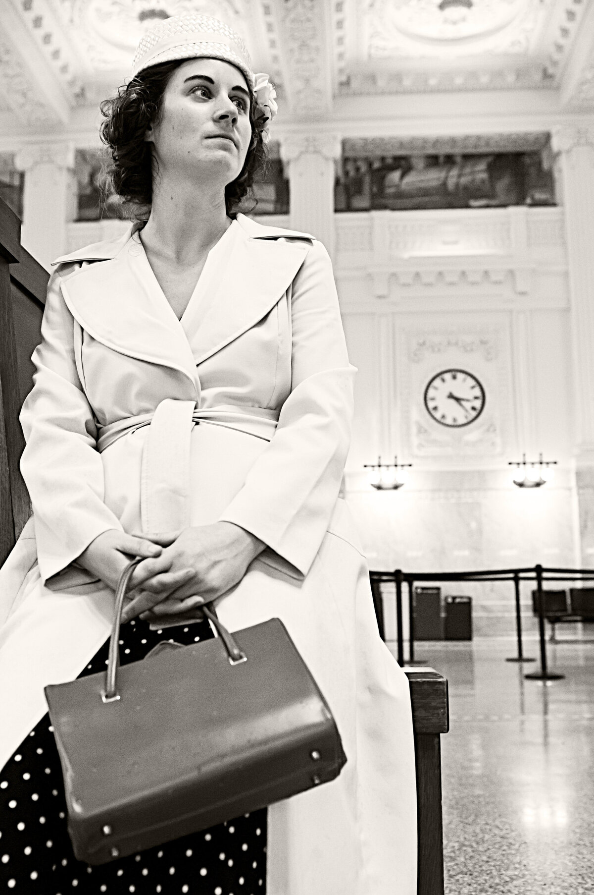 A black and white photo of a person standing in a train station