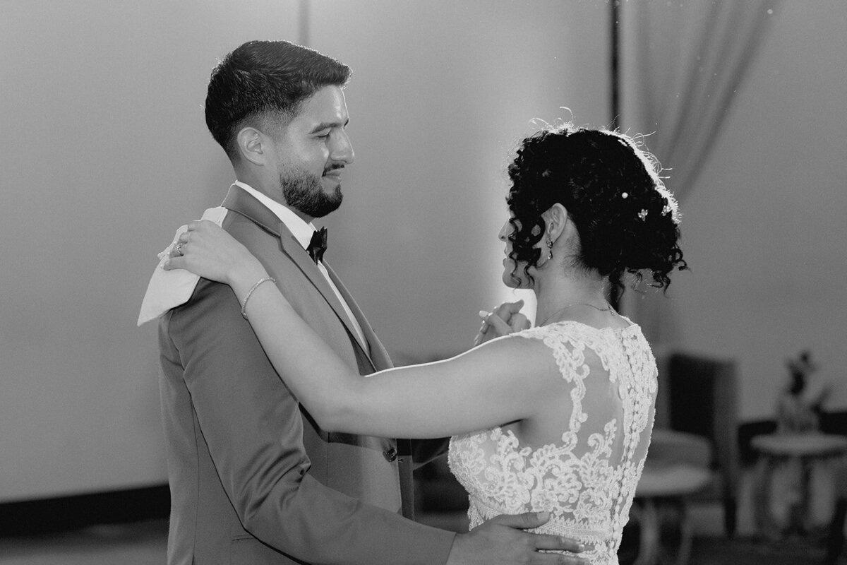 A black-and-white image of the bride dancing with a guest, both smiling and sharing a heartfelt moment.