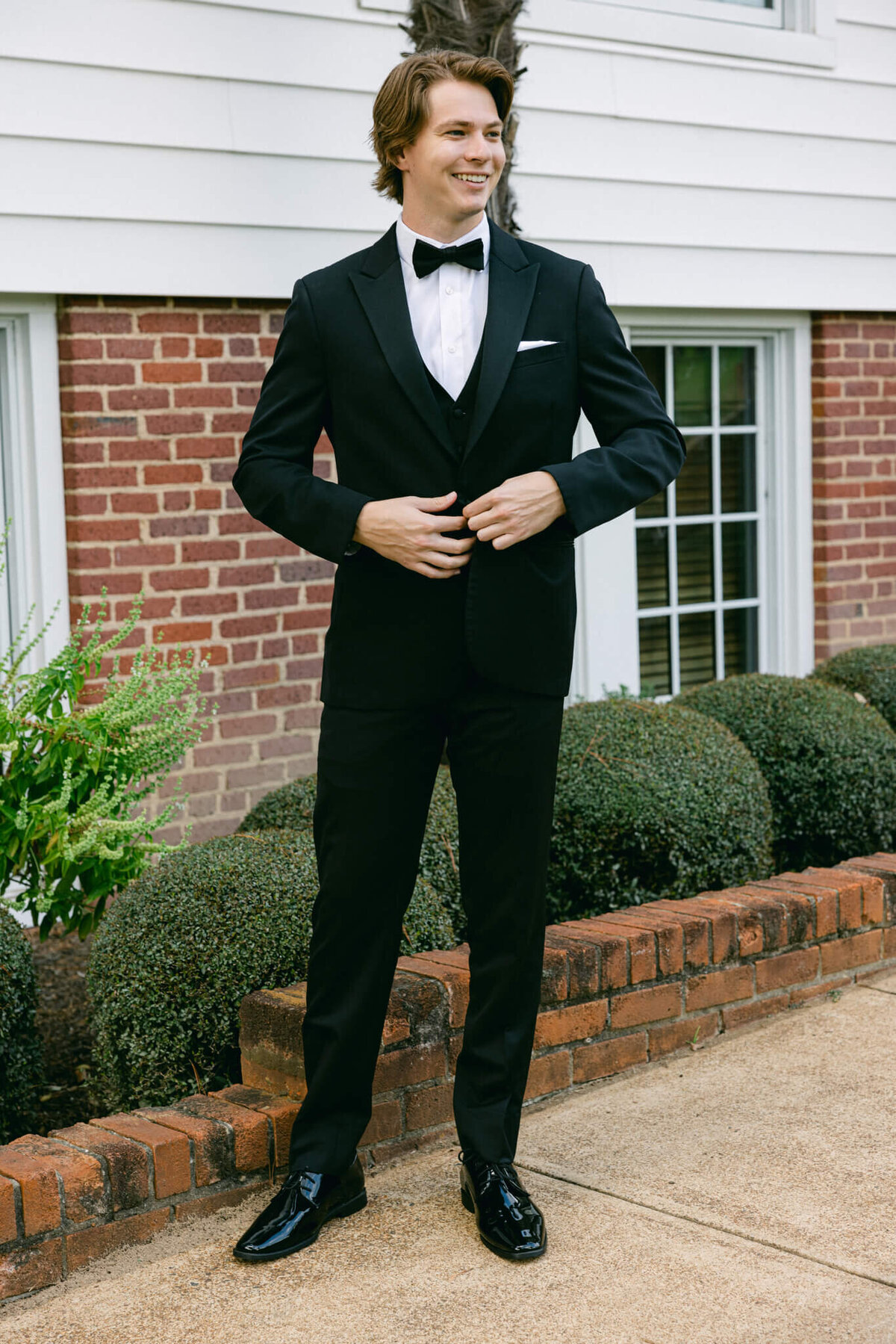 A wedding day portrait of the groom in his black suit.