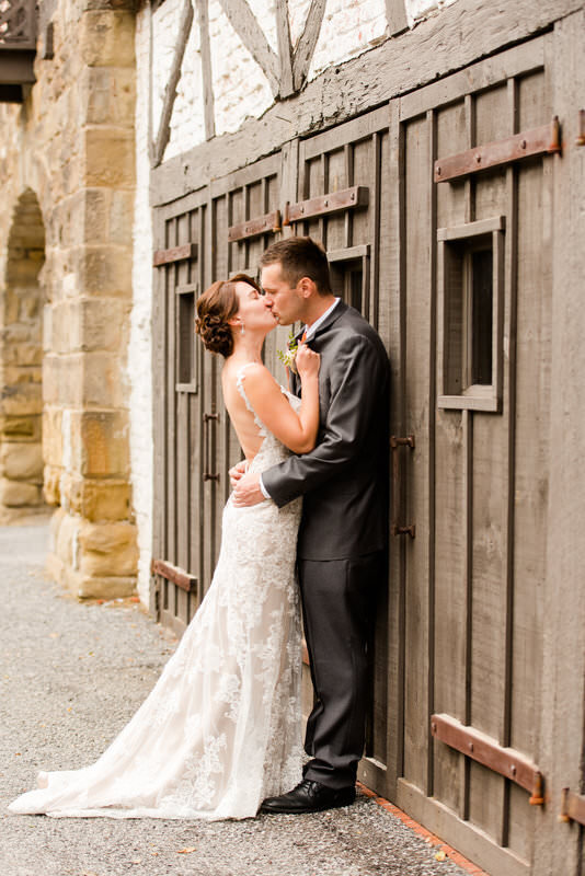 wedding picture of a couple kissing and leaning against a door at the Hyeholde