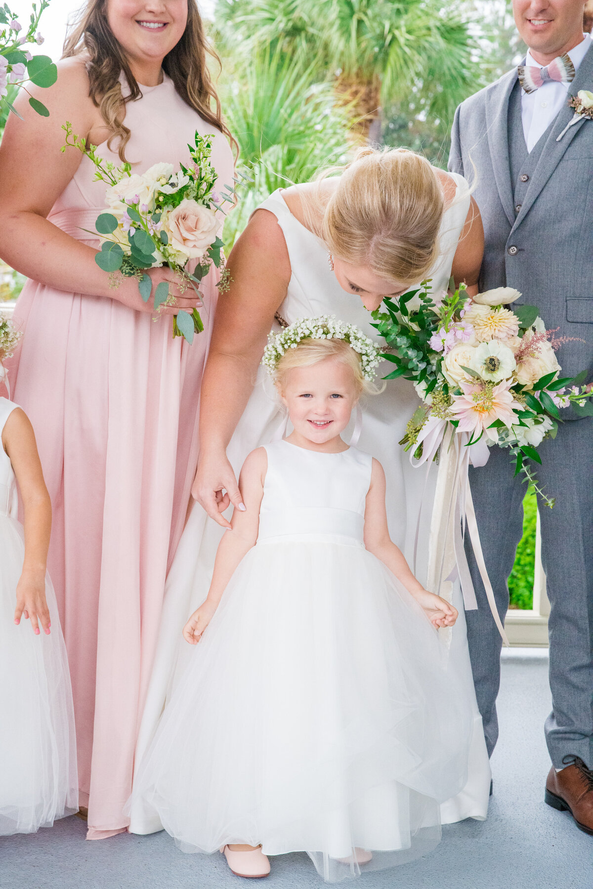 flower girl laughs and looks at the camera while bride looks on