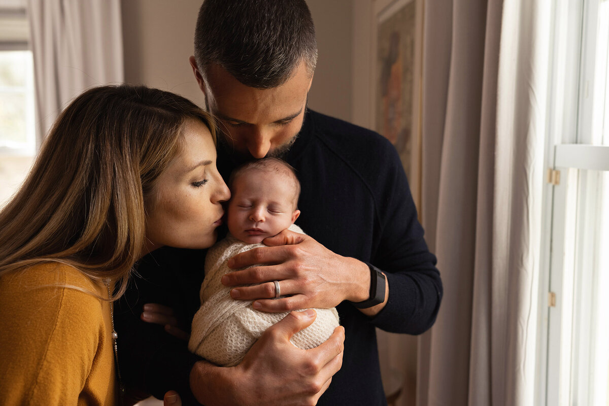 NJ Maternity Photographer captures Parents Kissing New Baby