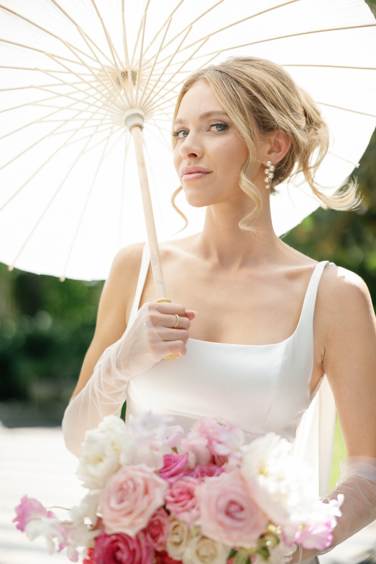bride holding pink bouquet and parasol