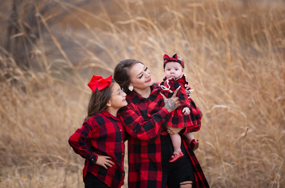 family standing with baby in golden fields