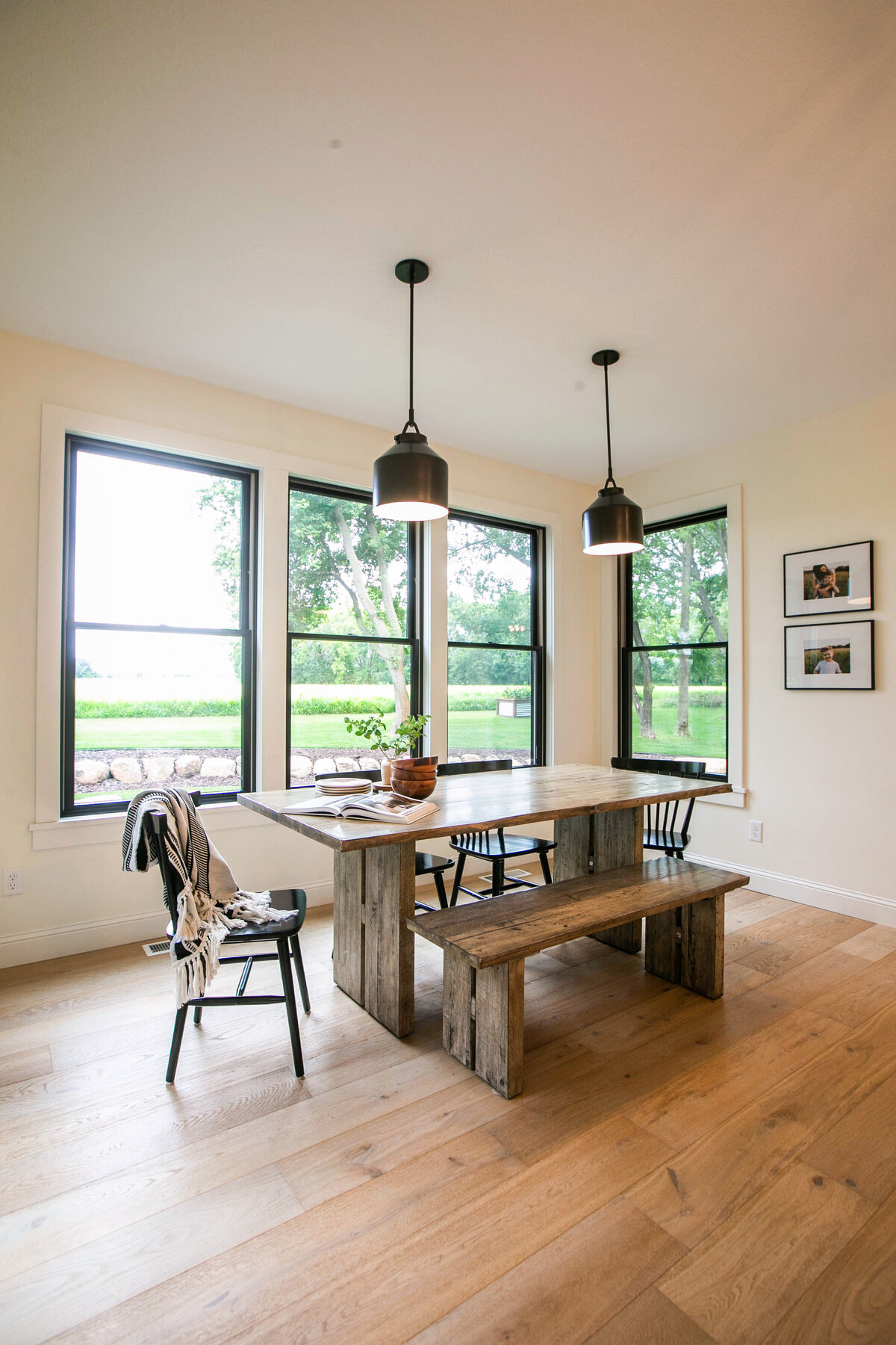 Open kitchen with eat in dining area, white cabinets, large island, and quartz countertops in an Otsego custom home