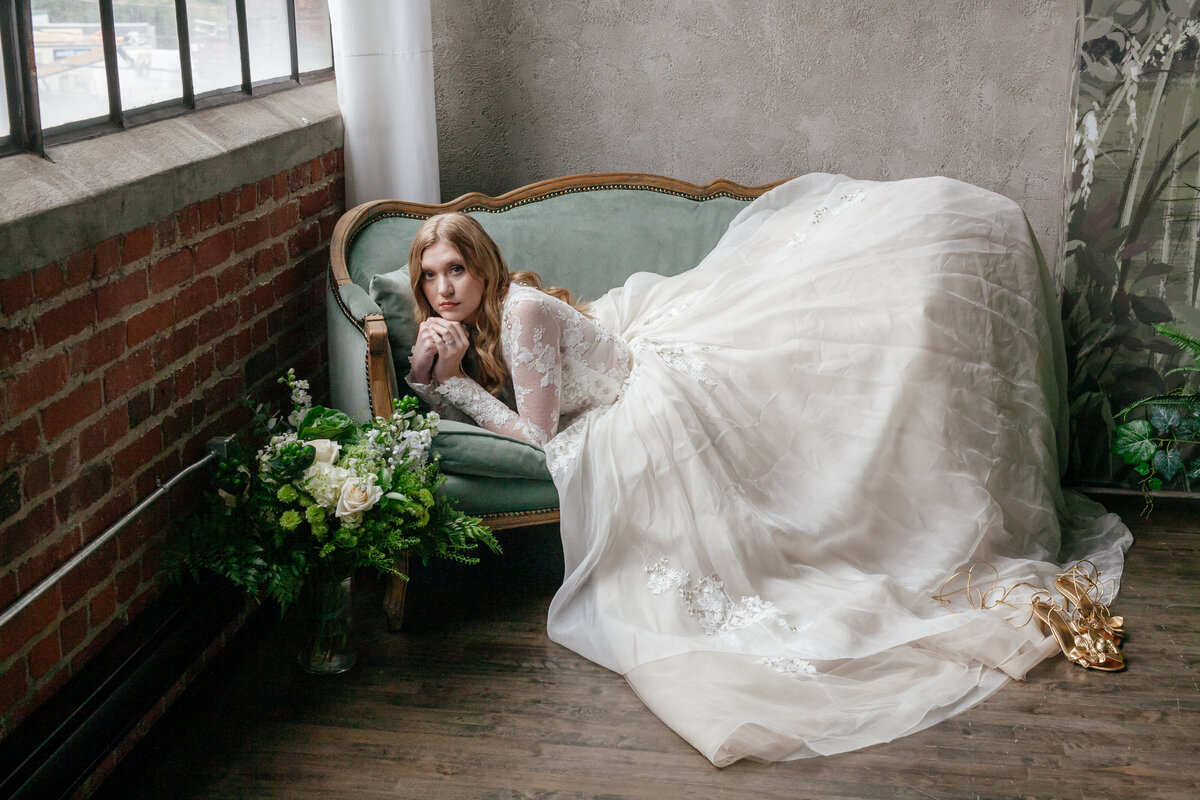 Bride laying on a vintage chaise lounge