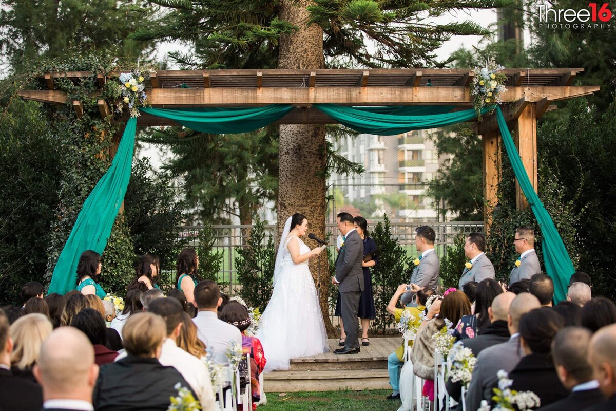 Bride reads her vows during her outdoor wedding at the Fullerton Community Center