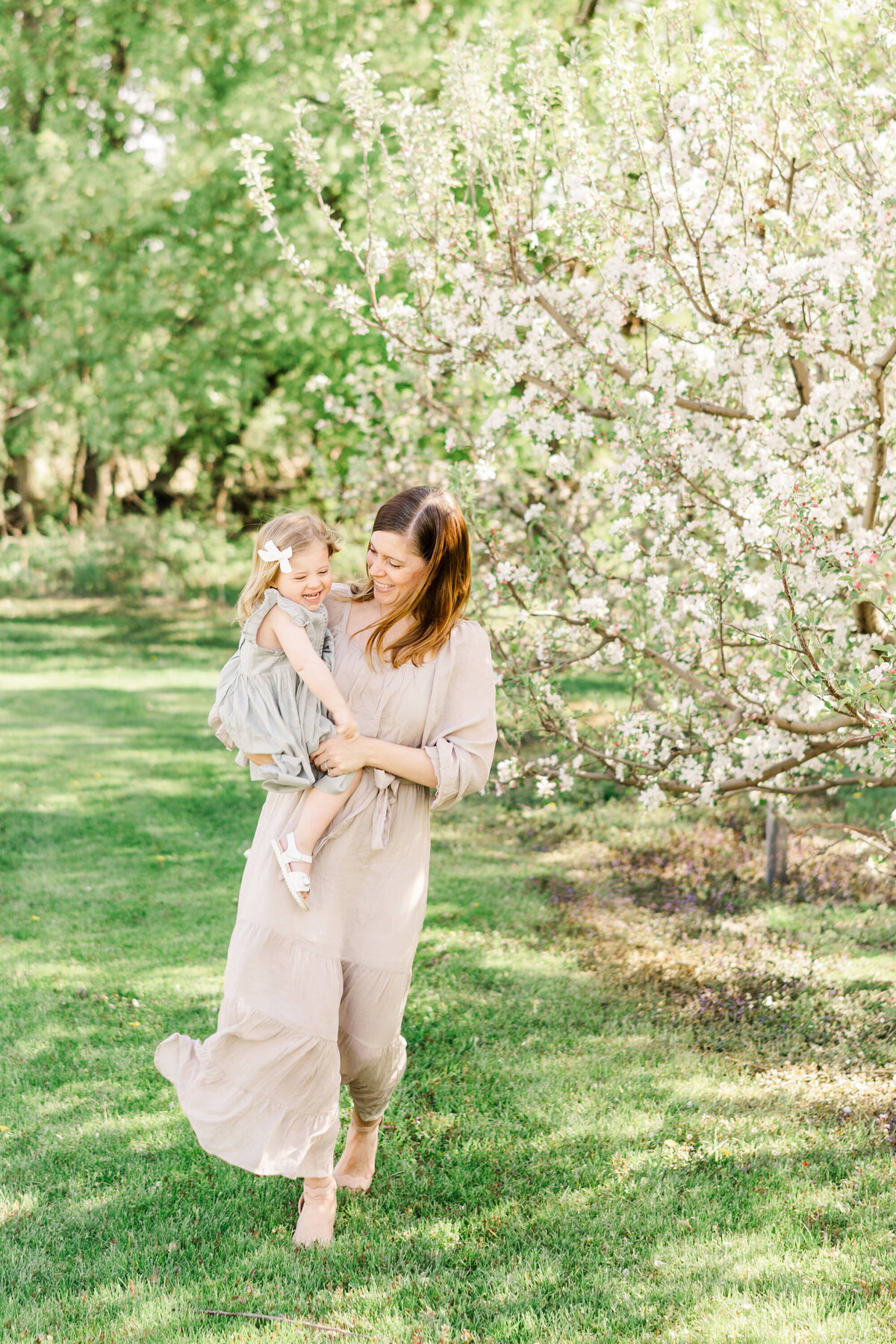 mother and daughter laughing together during a cherry blossom portrait session in Minneapolis