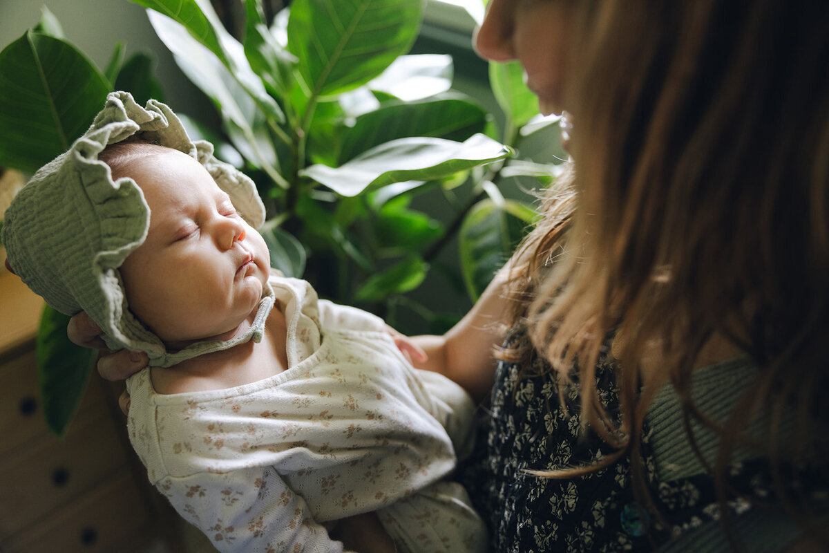 Mother gazes lovingly at her newborn baby. 