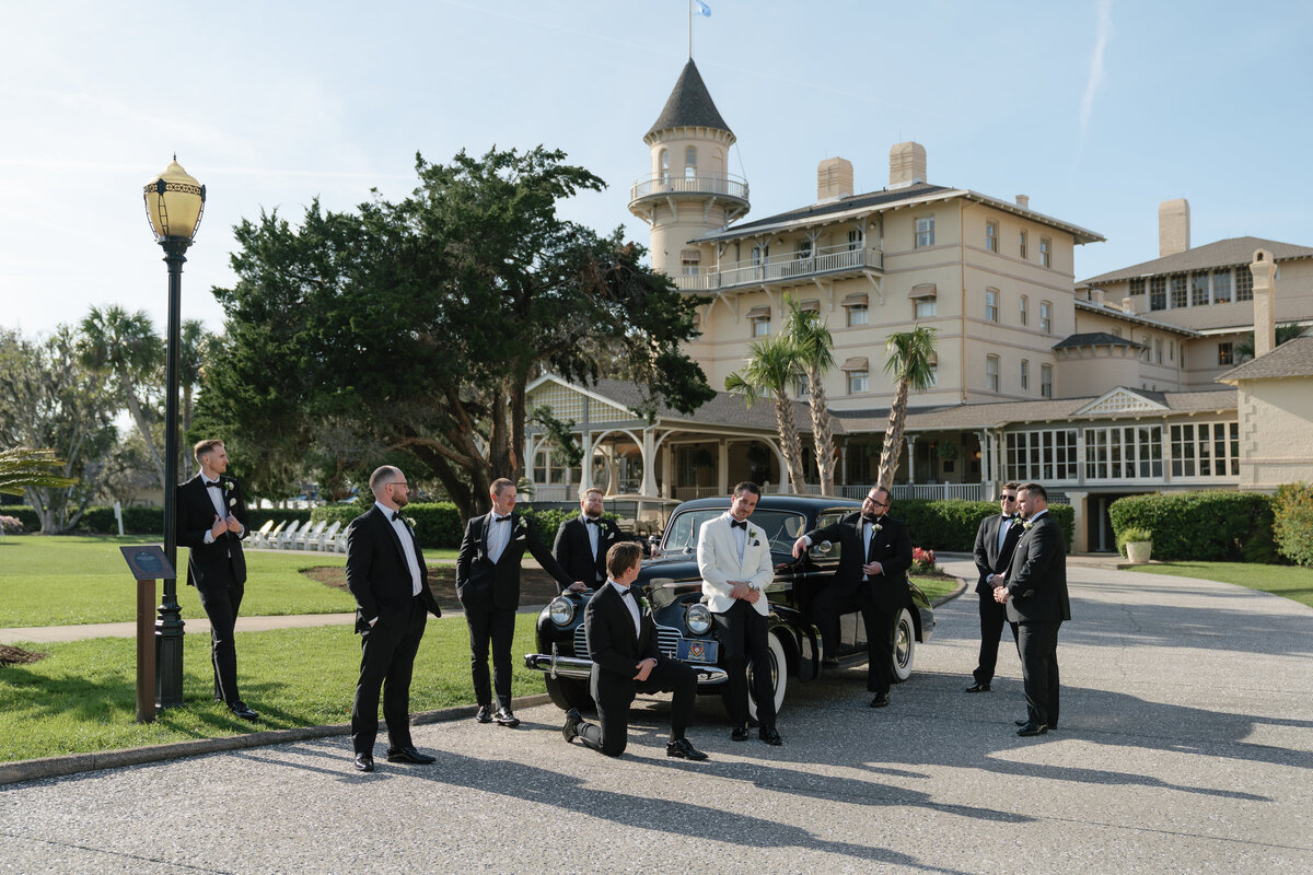 Groom and Groomsmen standing around a vintage car on wedding day posing for east coast photographer Shelby Ann Photos