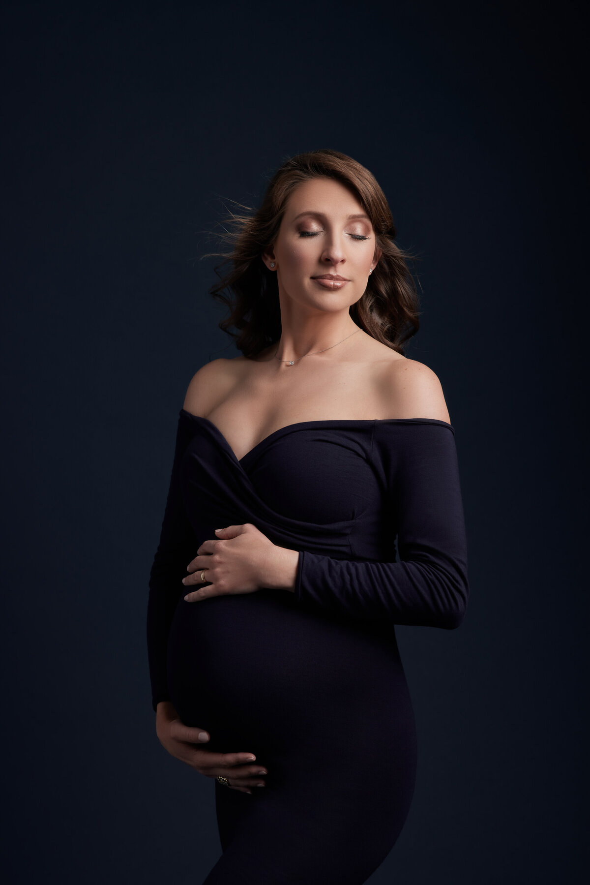 A woman with her hands around her pregnant stomach