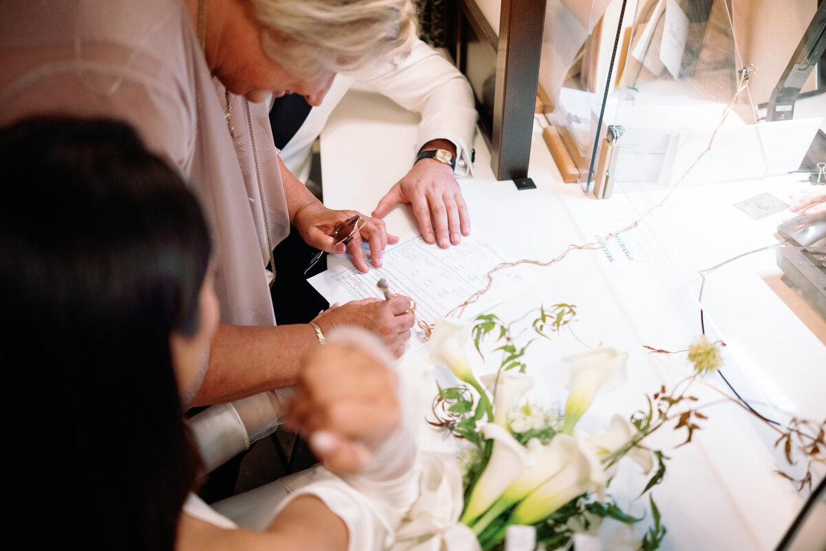 Close-up of the marriage license signing at New York City Hall with the bride, groom, and witness, photographed during Japna and Chris’s intimate elopement by NYC wedding photographer Perry Hancock.