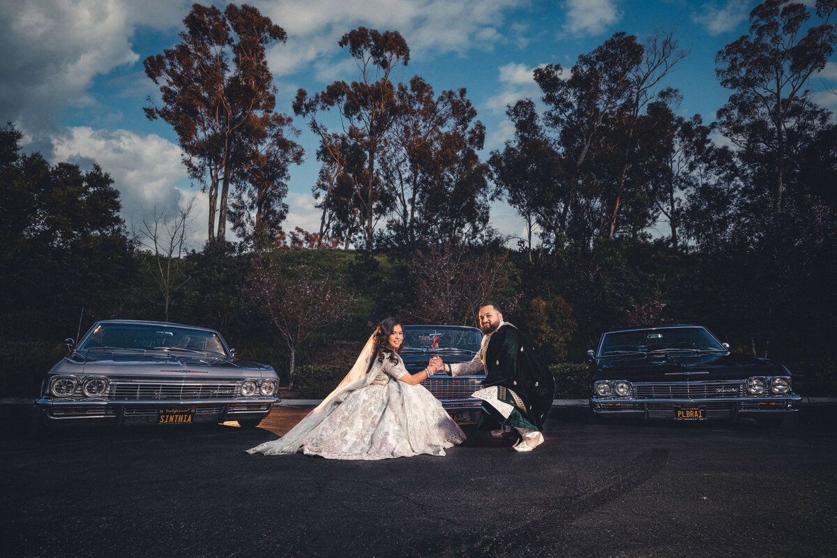 Bride and groom in front of sports cars at Southern California wedding