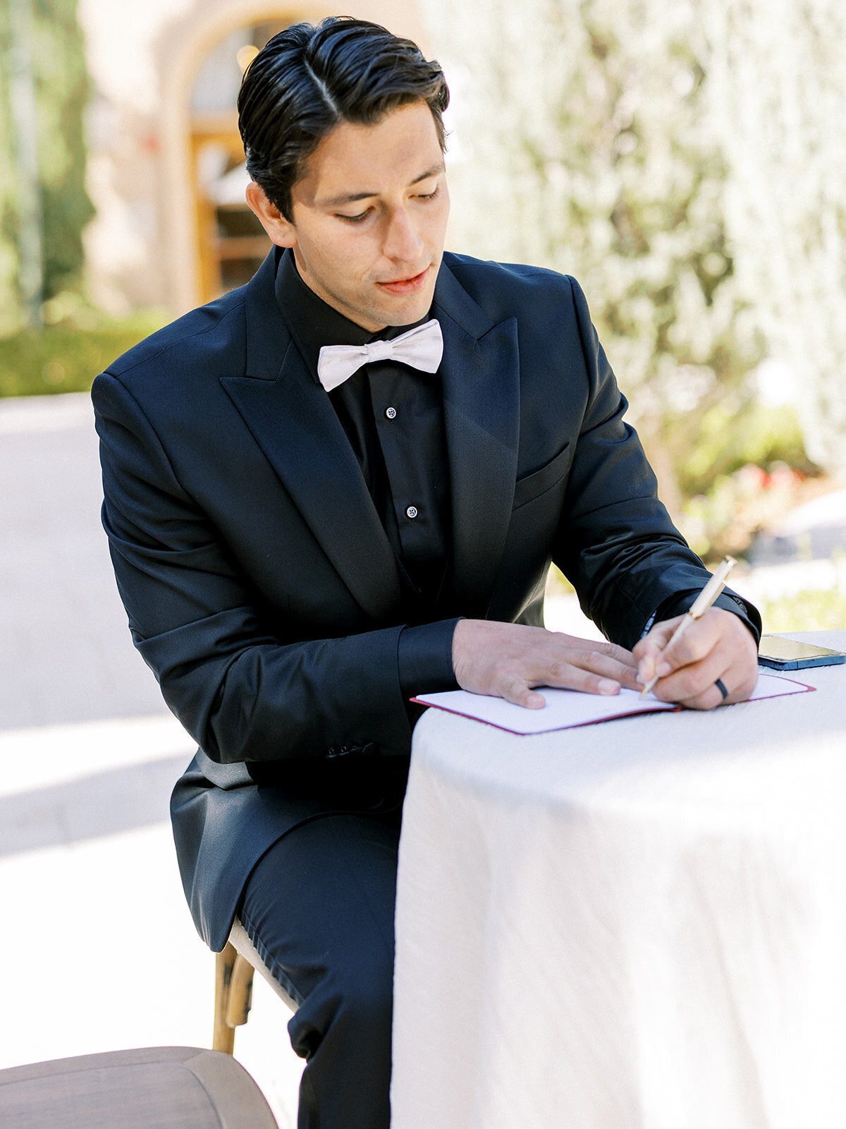 Groom writing a love letter before the ceremony at a romantic Santa Barbara wedding.