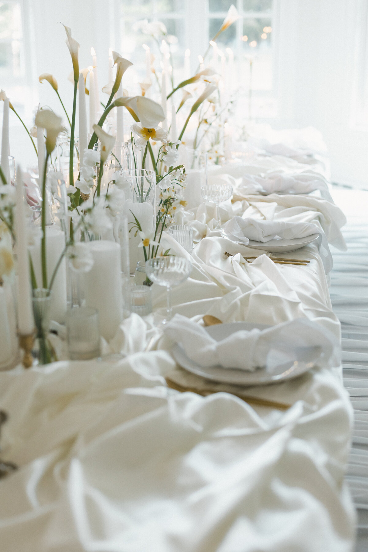 Reception setup with candlelight and elegant tablescapes, cinematic details.