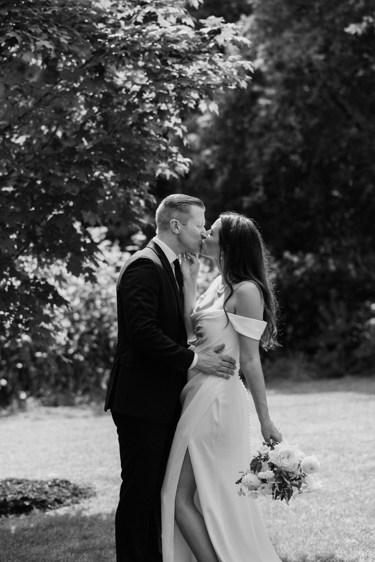 Bride and groom share a kiss outside of the wedding venue for their wedding photography