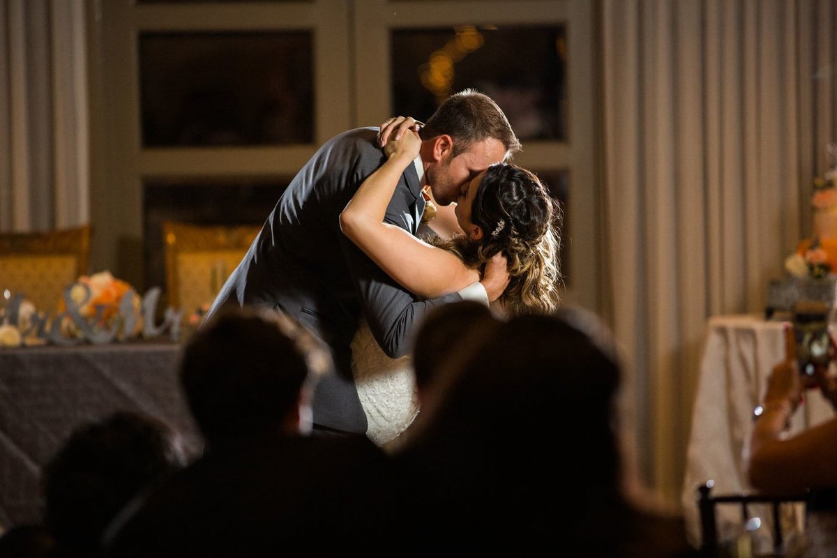Groom dips his Bride as he kisses her during the first dance