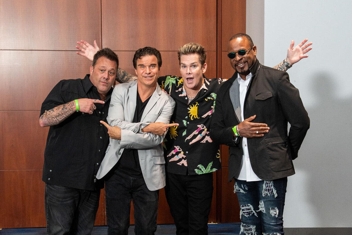 Four men posing together with playful expressions