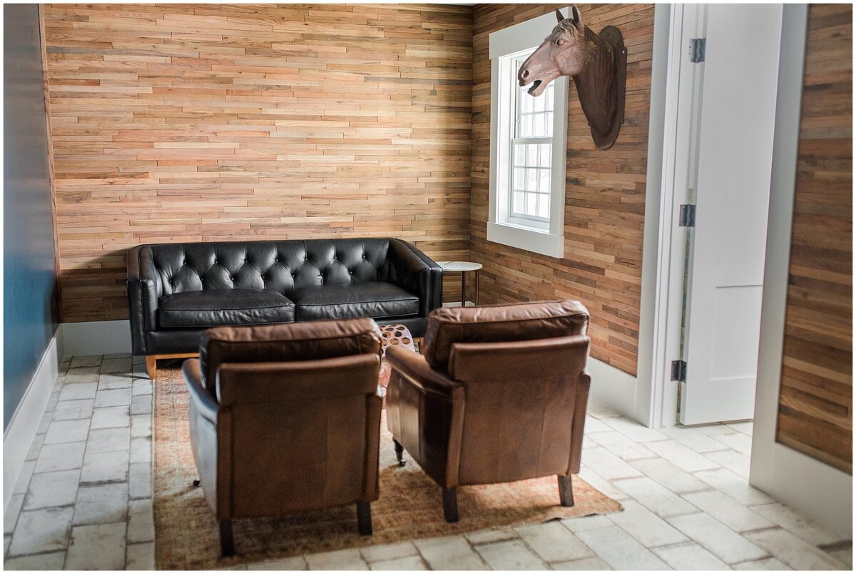 Groom's room at Walker Farms with shiplap walls and leather couches