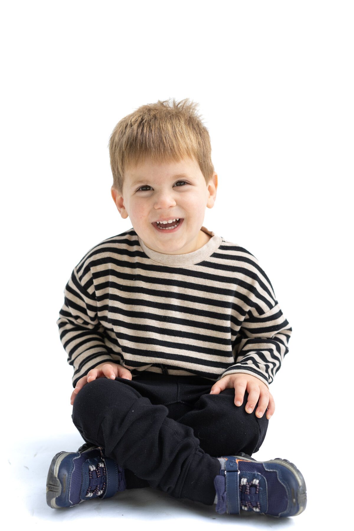 Toddler boy laughing while having his school photo taken