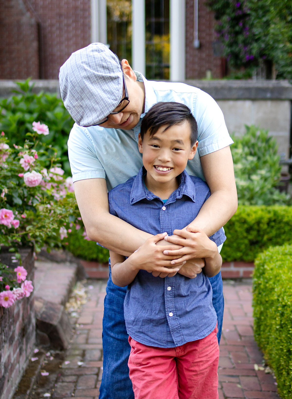 Golden hour portrait of a father and son in rose garden – joyful, natural light family photography by Ellobelle Photography in the San Francisco Peninsula kohl mansion Burlingame