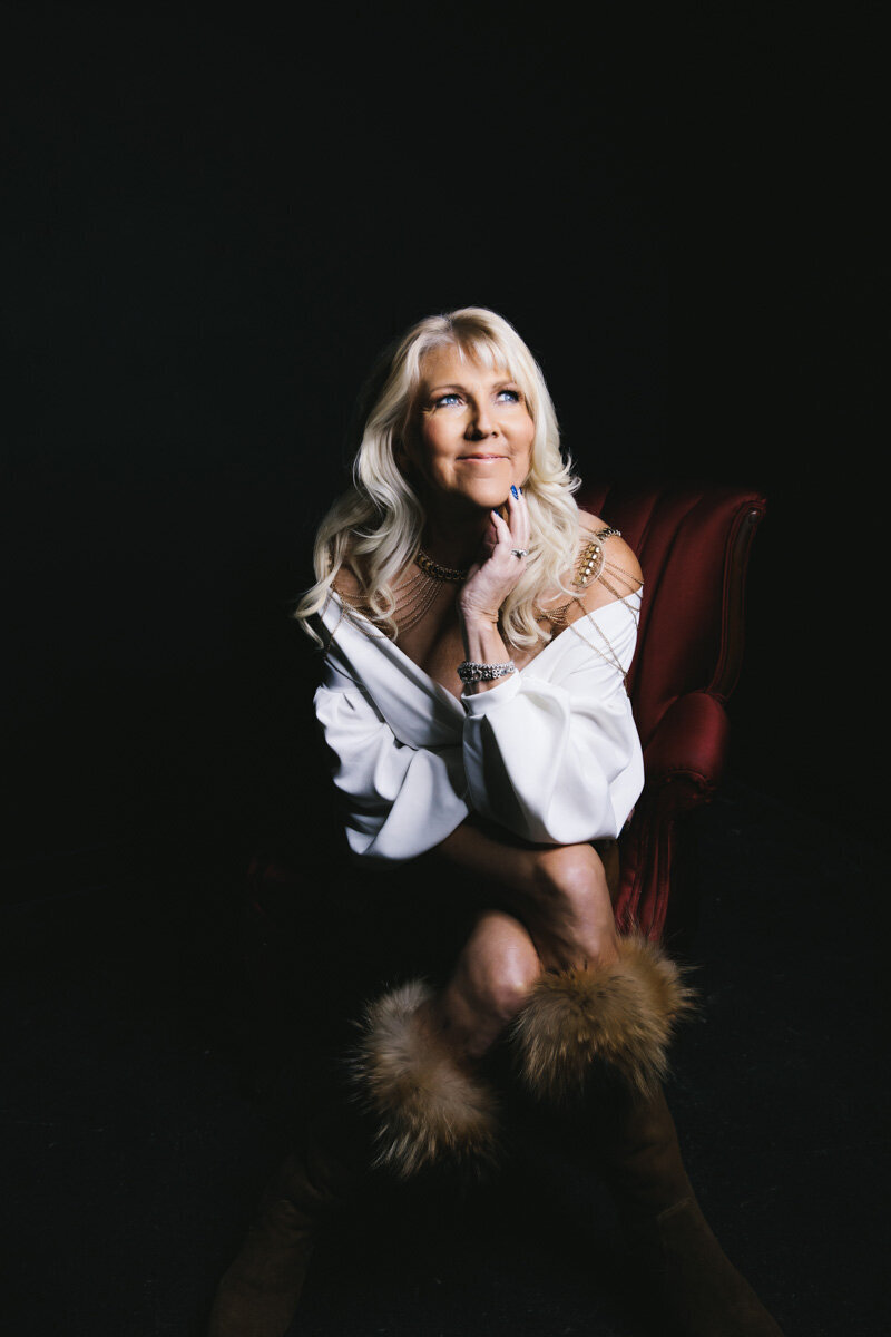 portrait of older woman wearing white shirt and fur boots