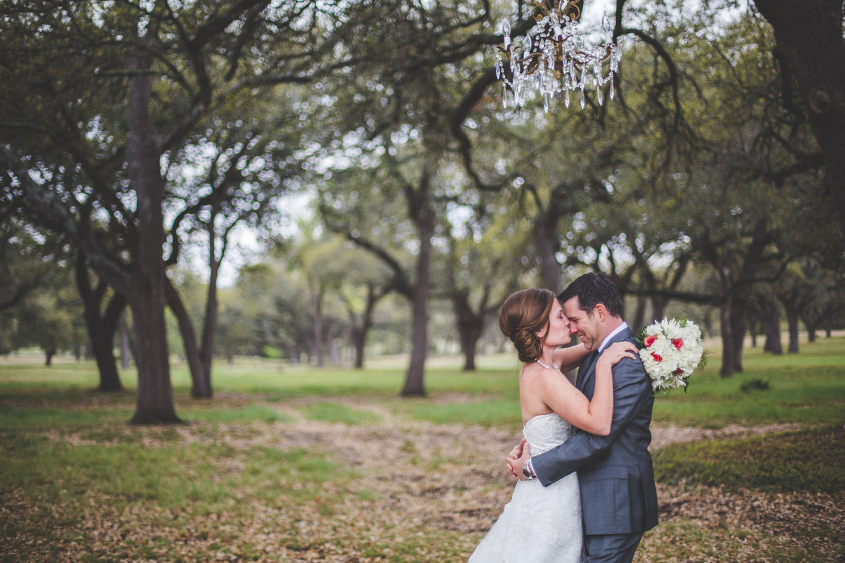 bride kissing groom on the nose under the trees at Hye Meadow Winery wedding venue
