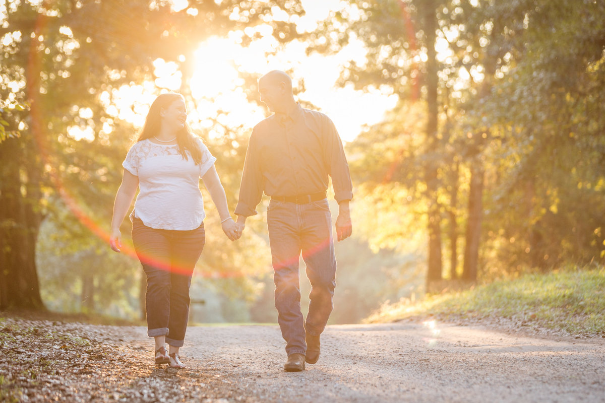 A couple enjoys an evening walk during their engagement session at Blakeley State Park in Spanish Fort, Alabama.