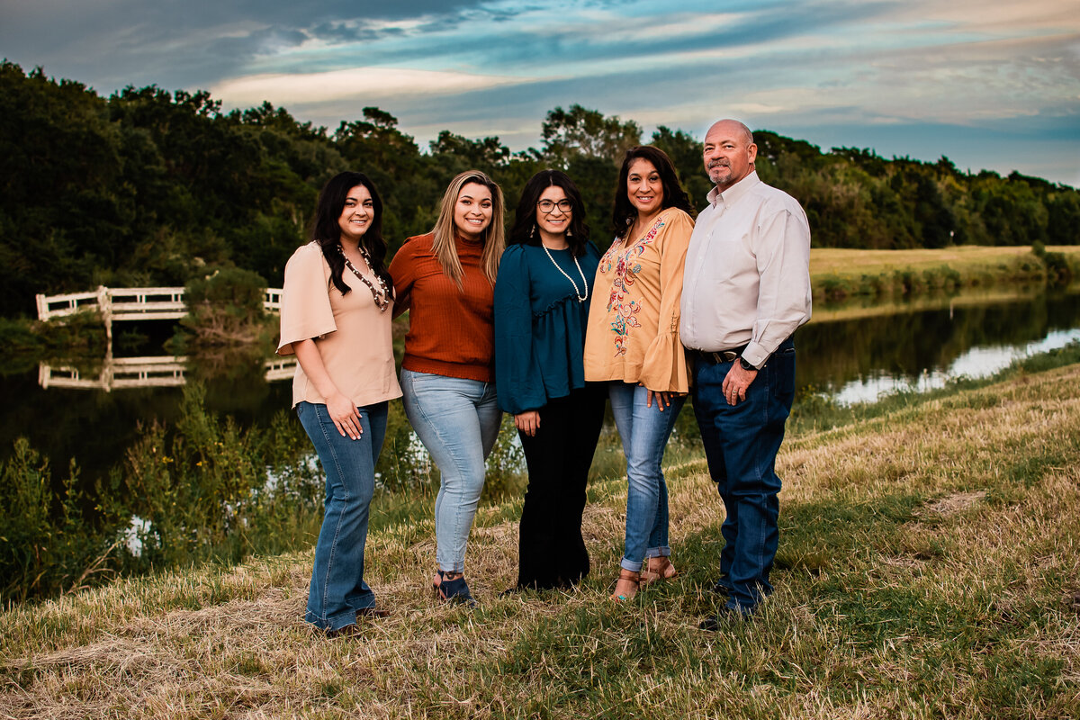A family of five stands in front of a creek at Jack Brooks Park.