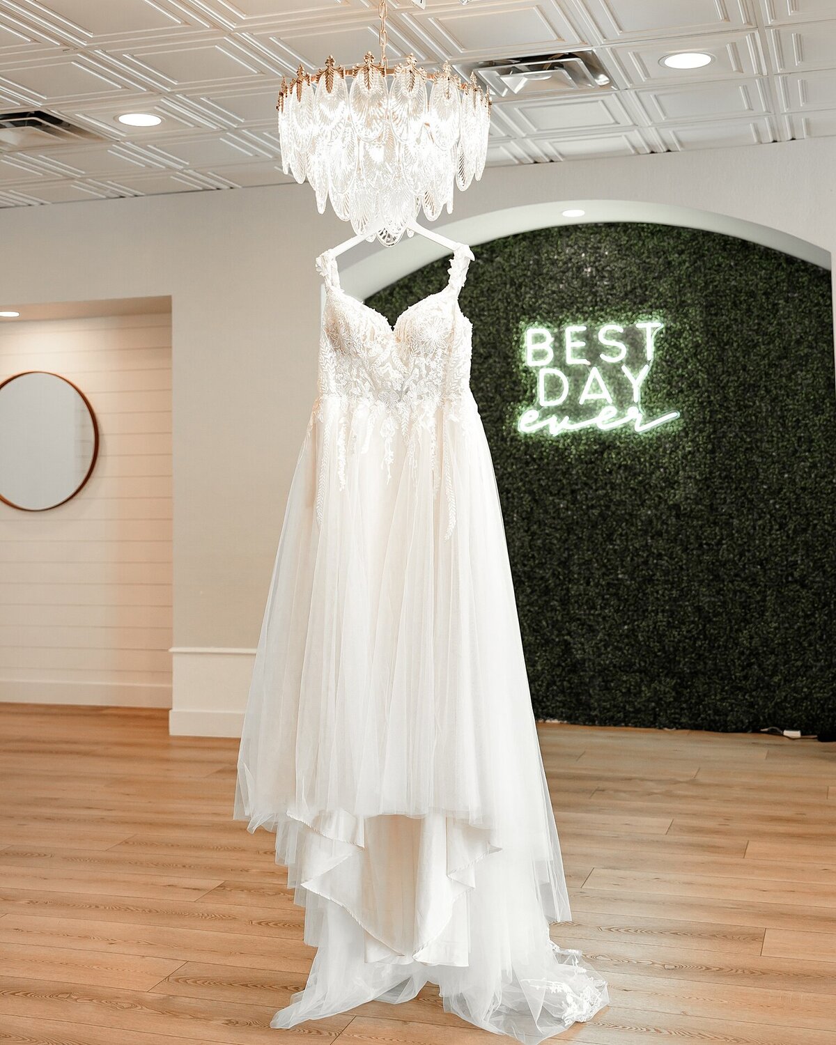 Photograph of brides dress hanging on chandelier at creekside wedding venue in colorado springs co