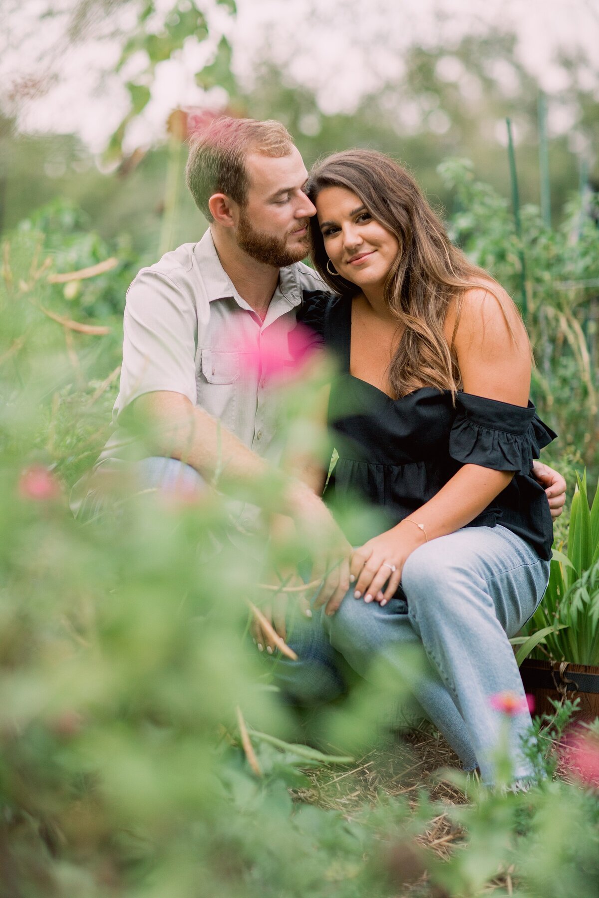 Engaged couple embrace in a garden