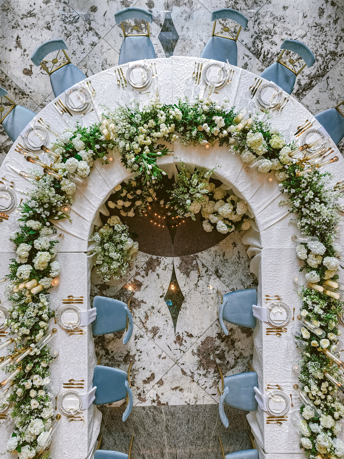 White and green floral runner with candelabras at gold and blue wedding
