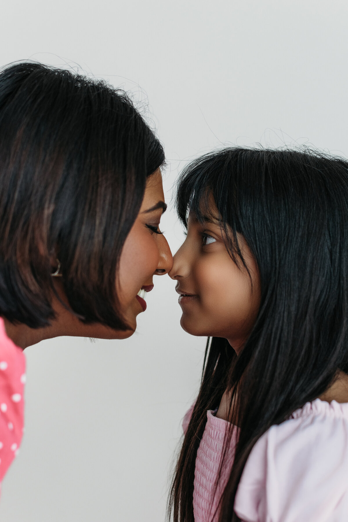 close up of a mother and daughter sharing an eskimo kiss in a bright, minimaloistic studio in bartlett, il