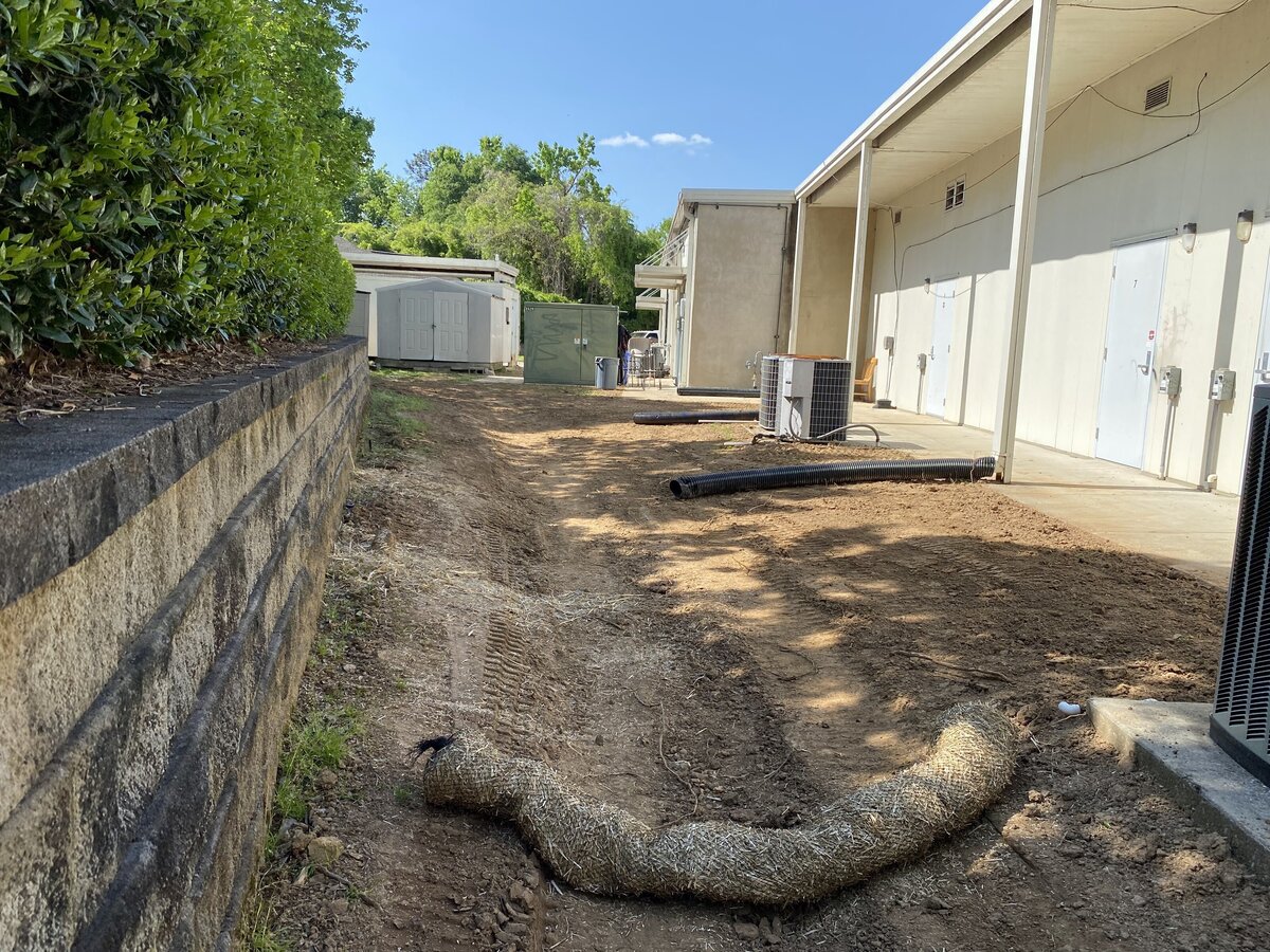 large-hose-on-dirt-floor-next-to-stone-wall