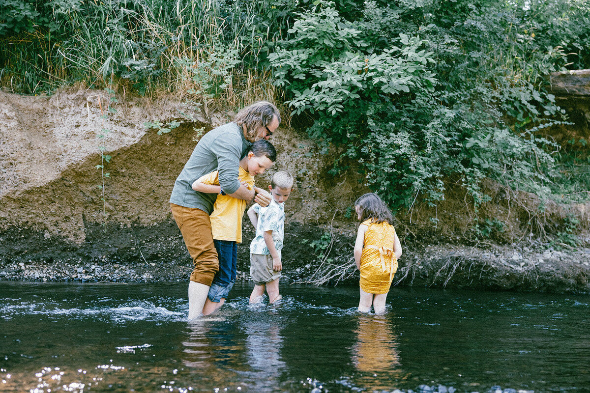 Family of four wade through the Mary's River in Corvallis Oregon together. 