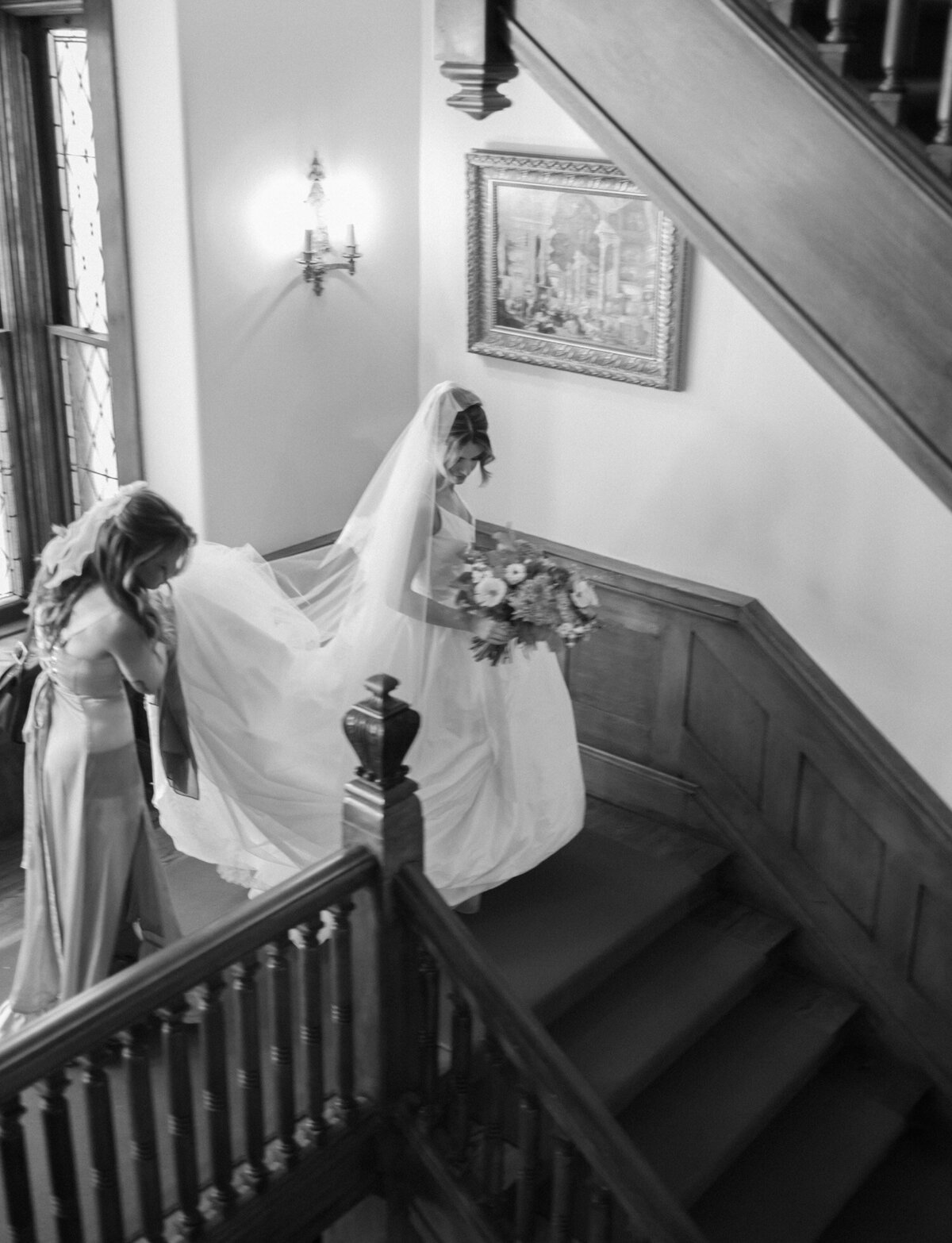 a bride is helped down stairs of a unique Detroit wedding venue in Michigan